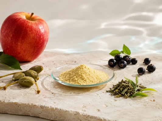 Quercetin-Pulver mit Apfel, Kapern, dunklen Beeren und Teeblättern als natürliche Quercetin-Quellen