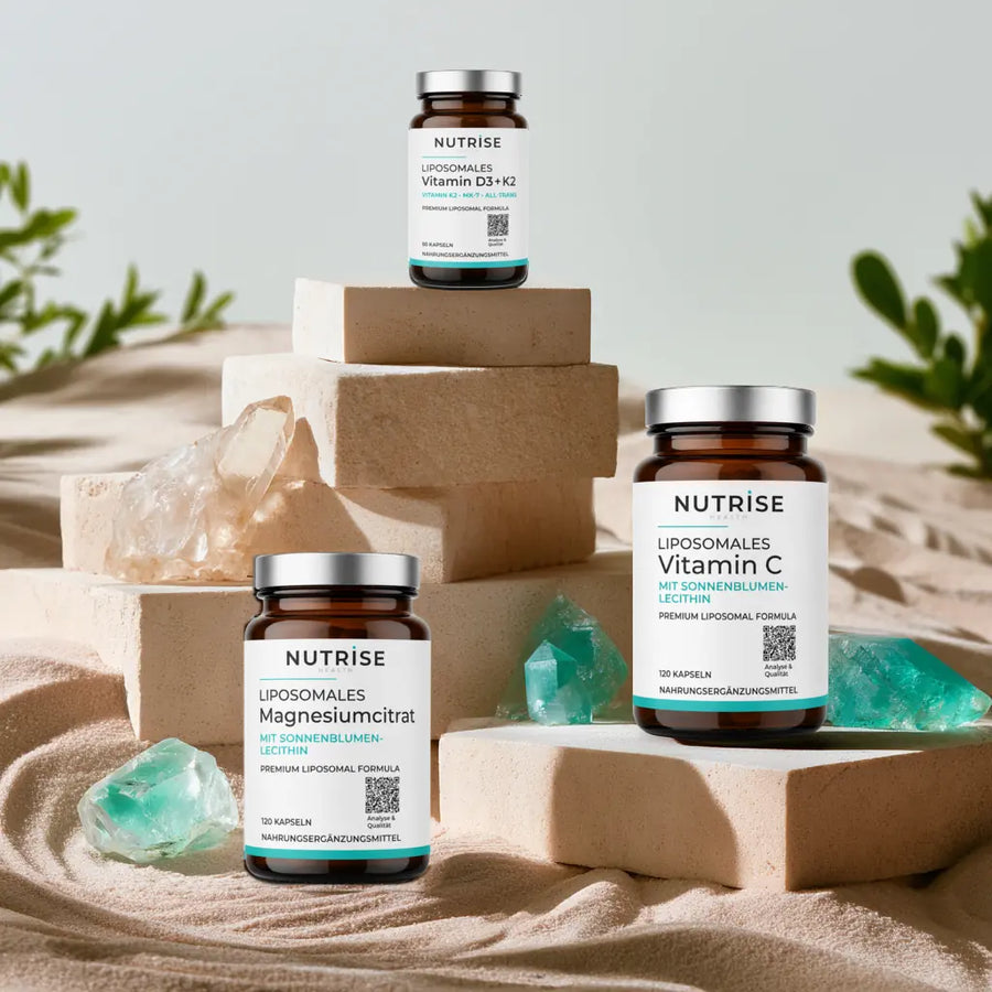 Liposomales Vitamin D3 + K2, Vitamin C und Magnesiumcitrat von Nutrise Health auf hellem Kalkstein mit Sand und türkisen Kristallen.