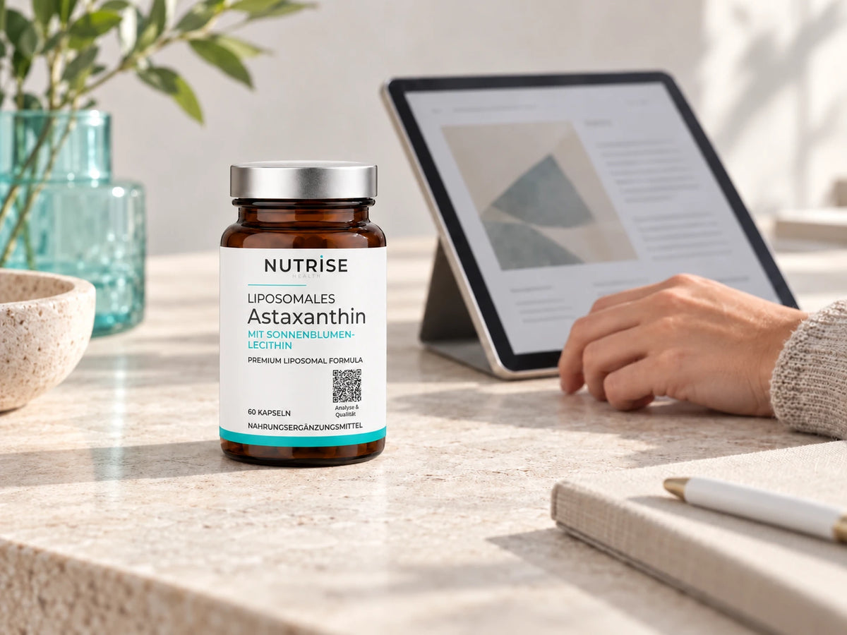 Nutrise Astaxanthin im Braunglas neben einem Tablet mit Produktunterlagen