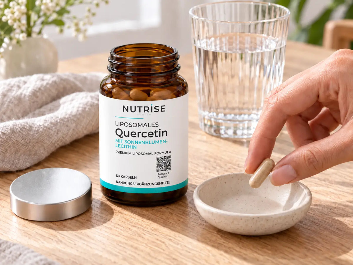 Eine Quercetin-Kapsel neben dem geöffneten Nutrise-Braunglas und einem Glas Wasser