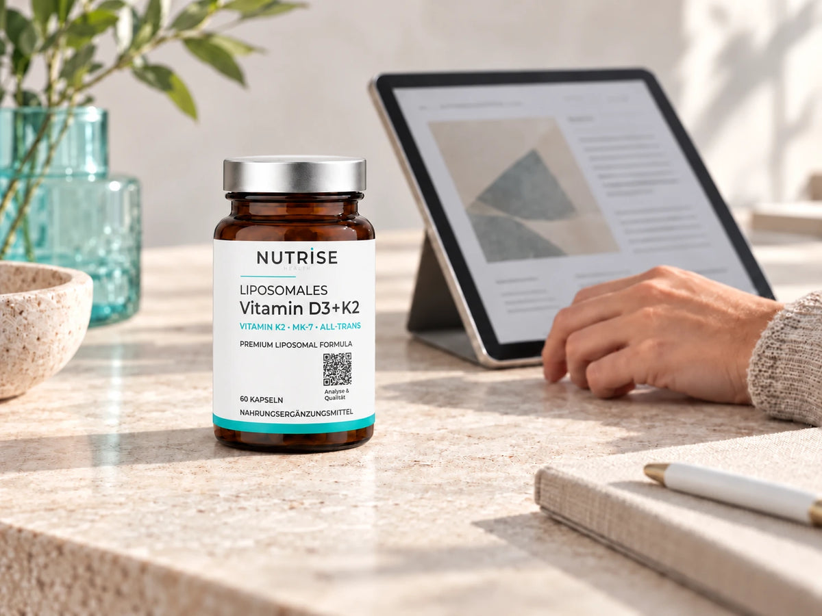Nutrise Vitamin D3 + K2 im Braunglas neben einem Tablet mit Produktunterlagen